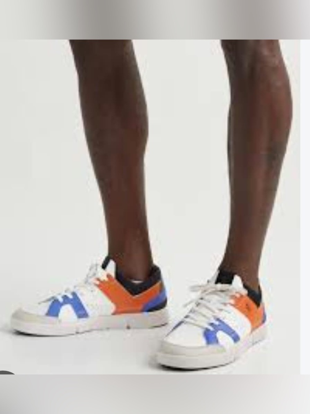 On Running White Sneakers with Blue and Orange Accents